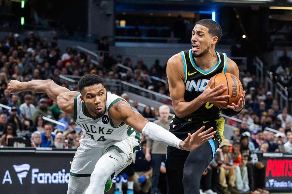 Indiana Pacers guard Tyrese Haliburton (0) dribbles the ball while Milwaukee Bucks forward Giannis Antetokounmpo (34) 